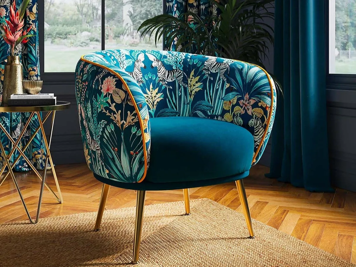 Teal floral fabric upholstered tub chair with gold coloured legs