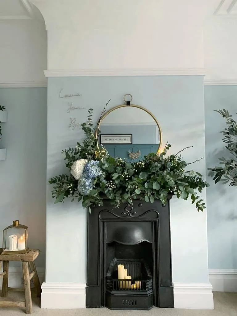 Pale blue wall and black-painted fireplace