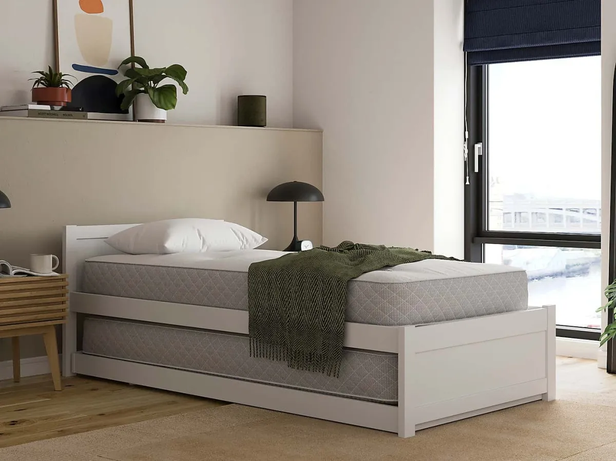 White-painted single bed frame with pull-out bed in base