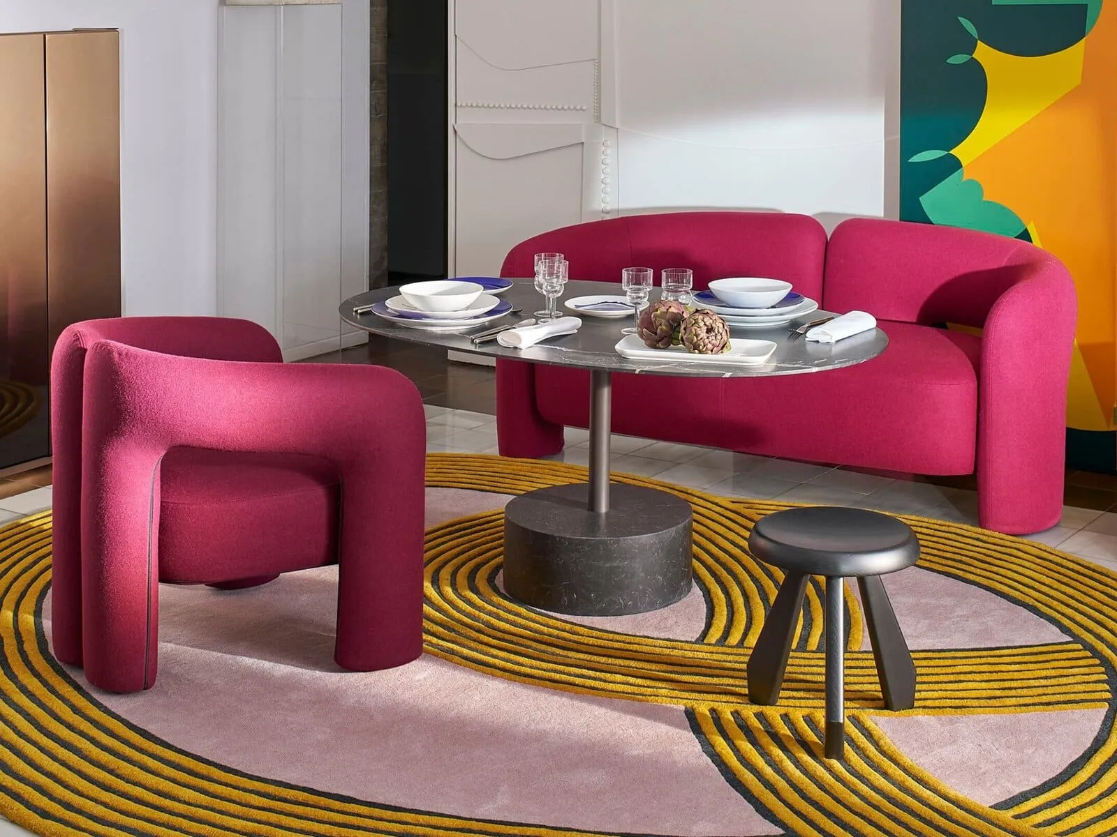 Curved sofa and armchair upholstered in bright pink fabric