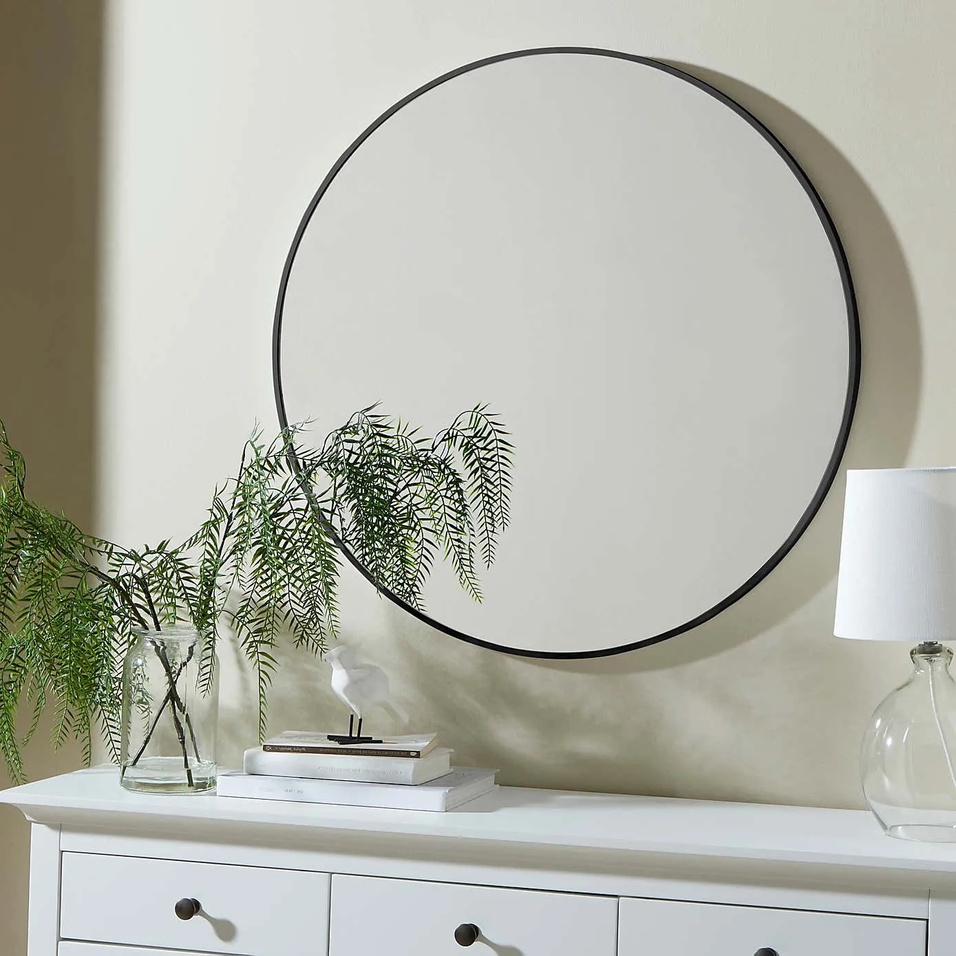 Round wall mirror with a black frame