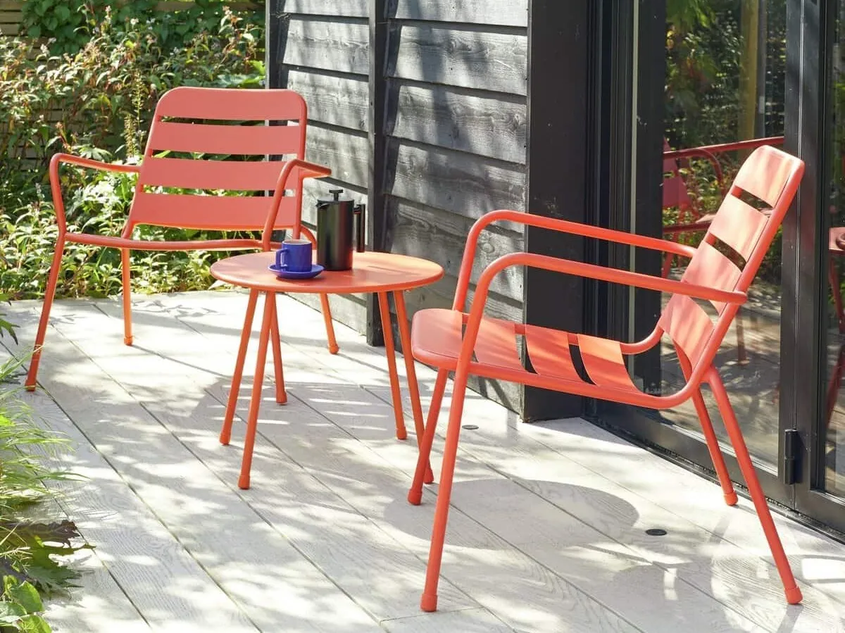 Pair of red metal garden chairs and a matching table