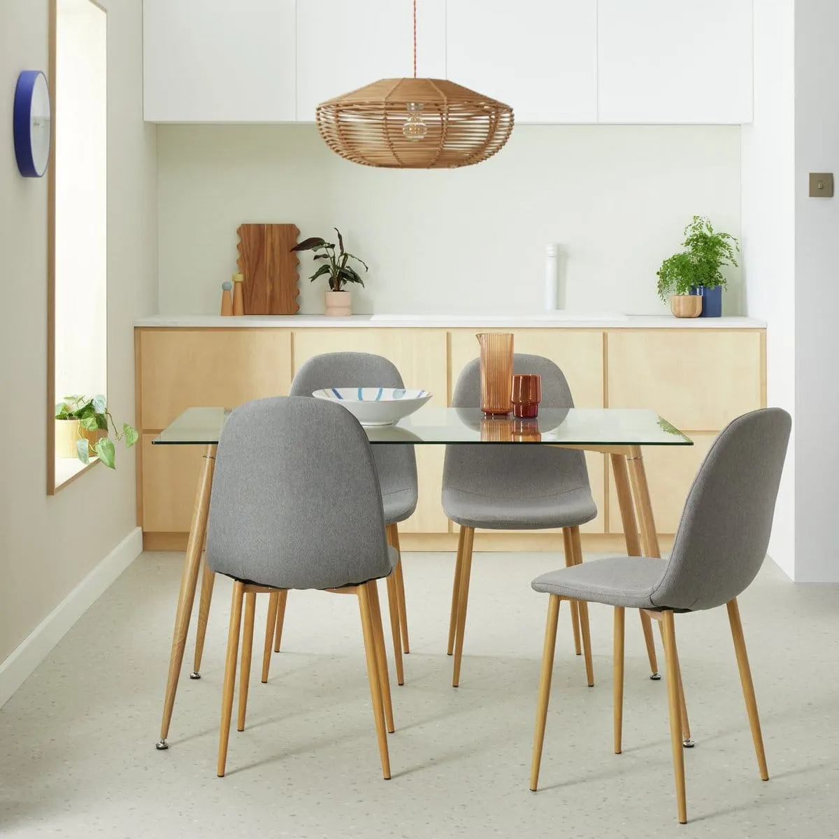Glass topped dining table on oak legs with 4 grey dining chairs