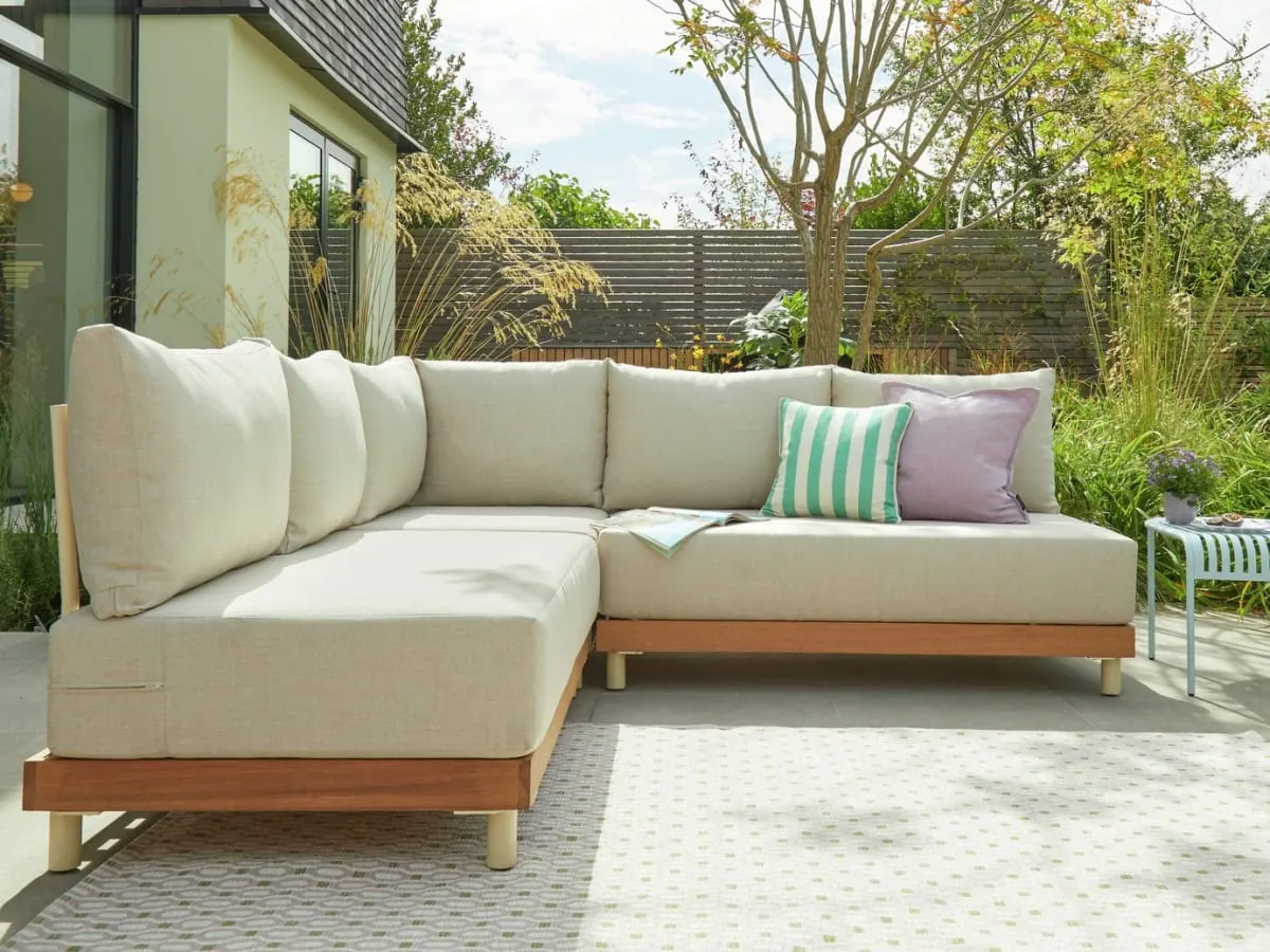 Modular garden sofa with cream cushions