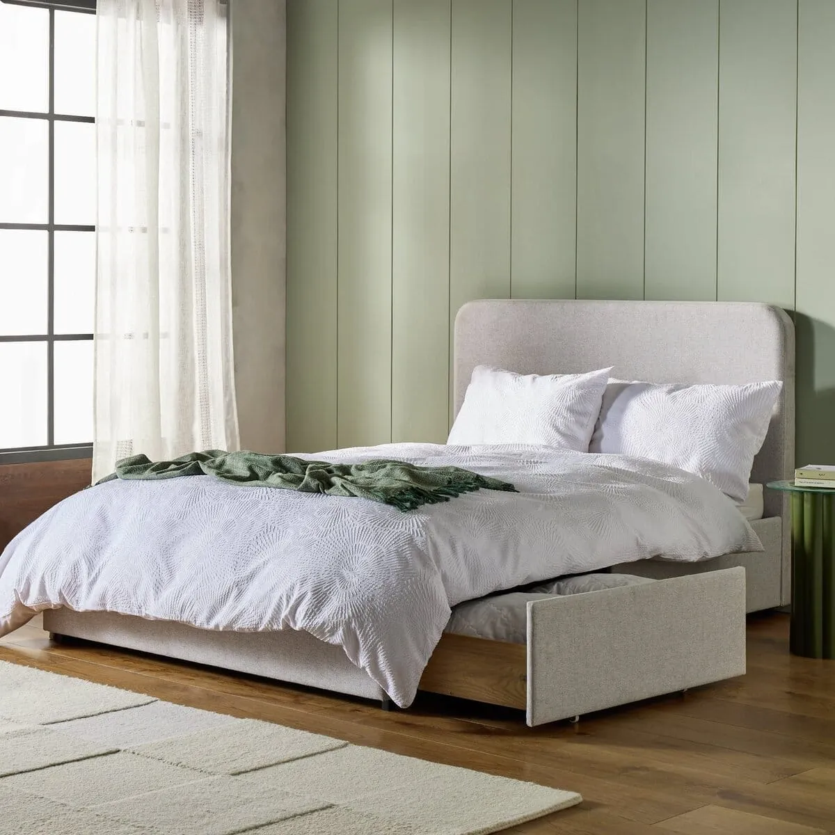 Grey fabric upholstered bed frame with storage drawers in base