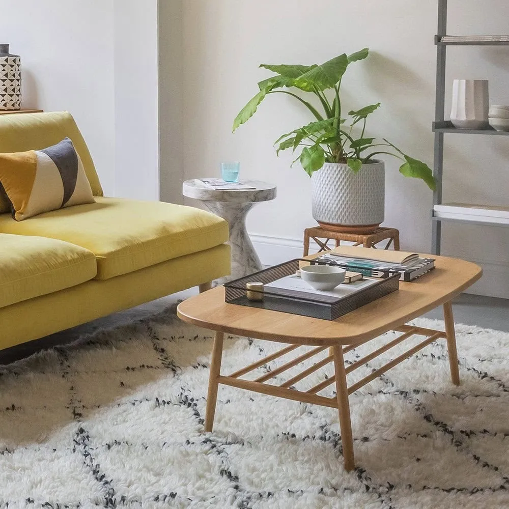 Curved edge oak finish coffee table with spindle shelf