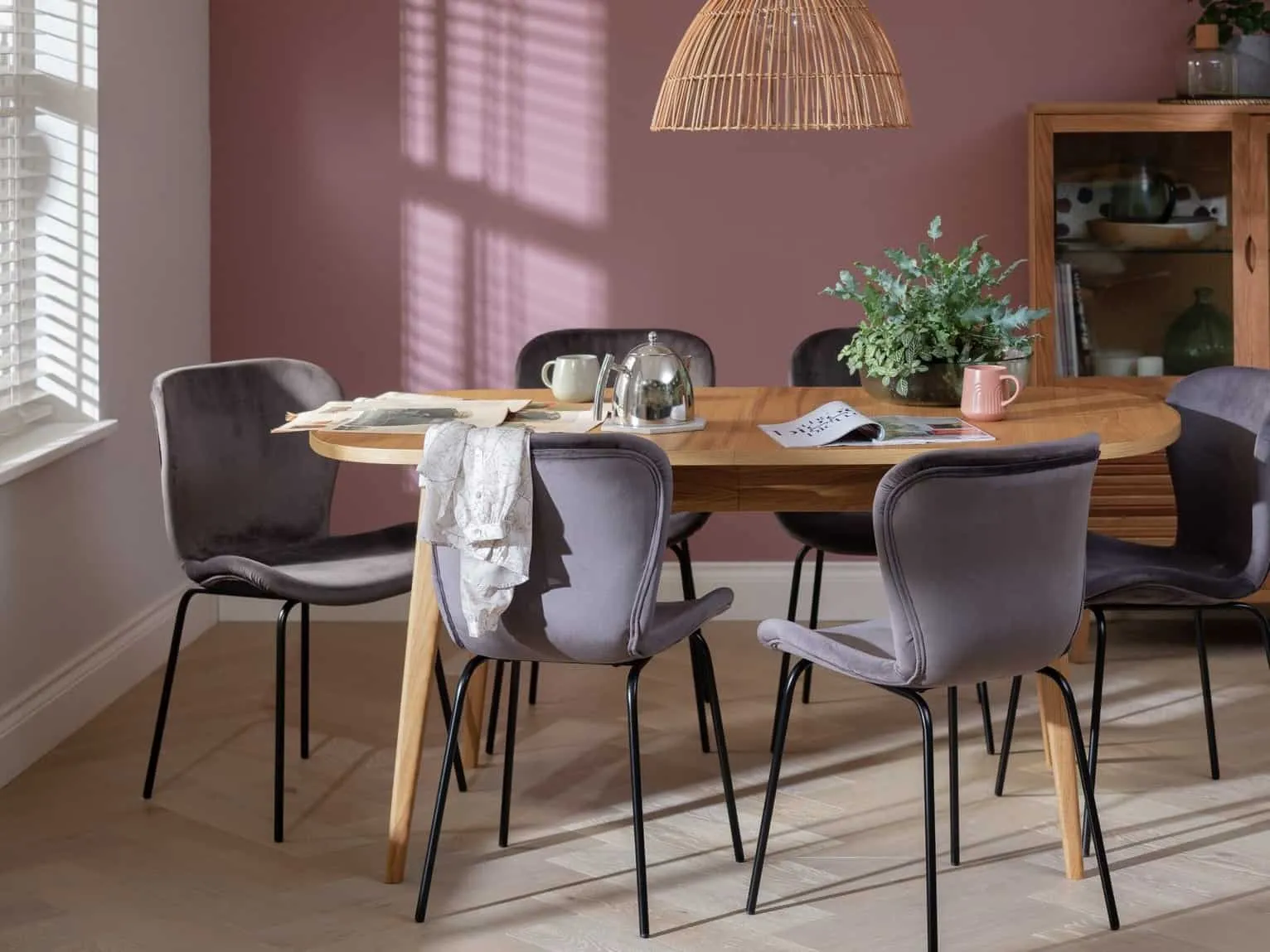 Oak dining table and six grey velvet upholstered chairs