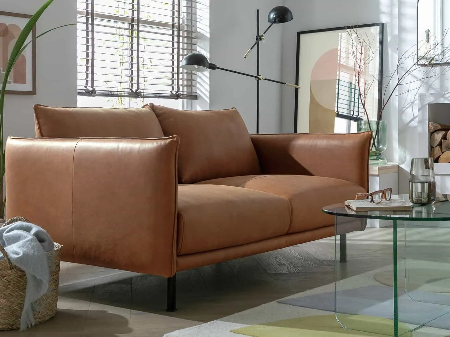 Tan leather sofa with black metal legs