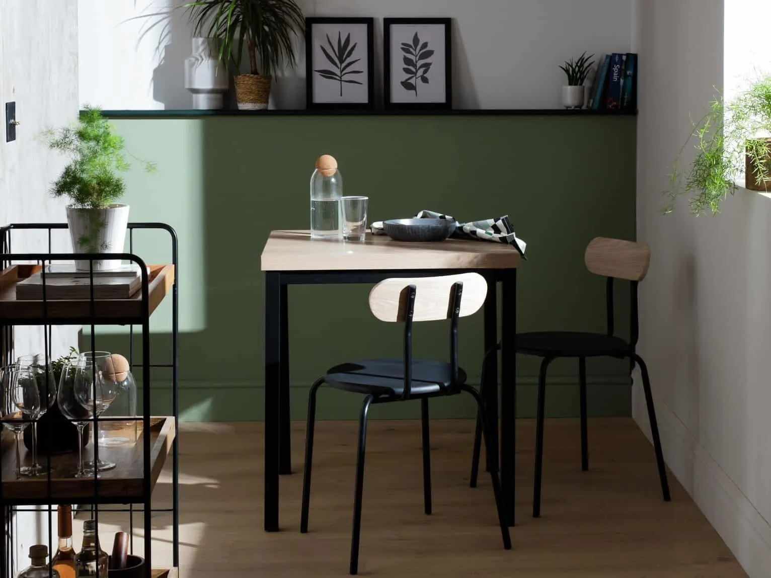 Square dining table with black frame and wood-effect top plus a pair of matching dining chairs