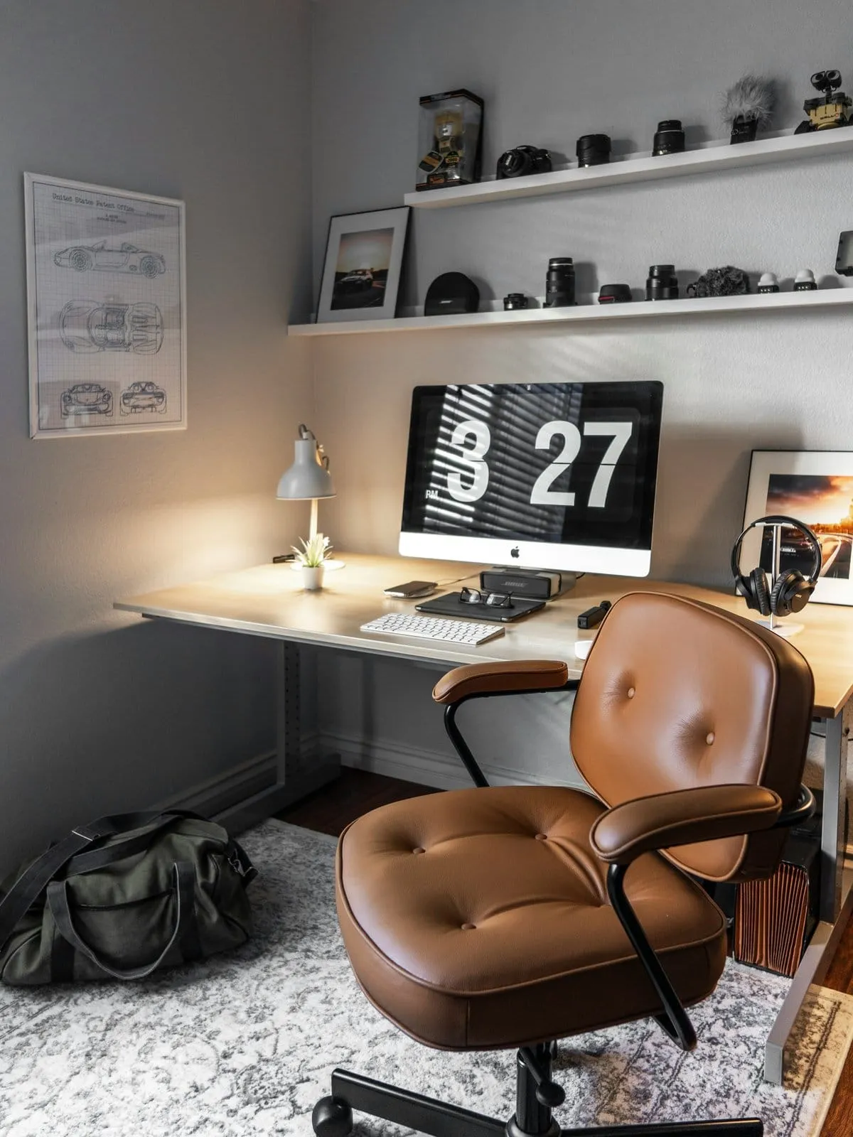 A contemporary home office set up with a desk, chair and wall shelves