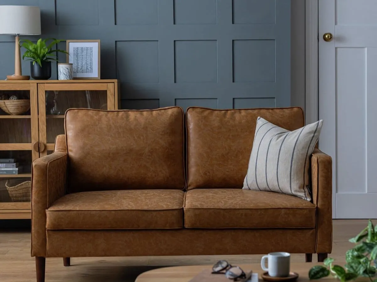 Tan leather sofa with wooden legs