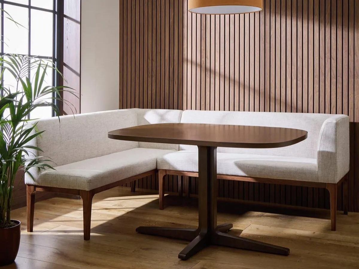Grey fabric corner bench and square walnut dining table