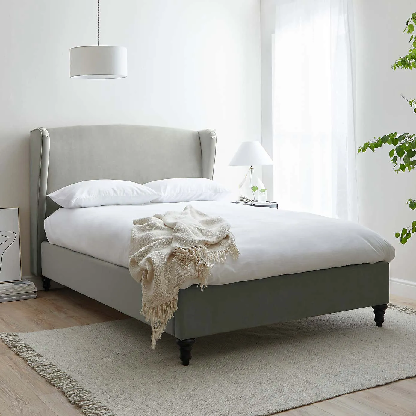 Grey fabric upholstered bed with winged headboard