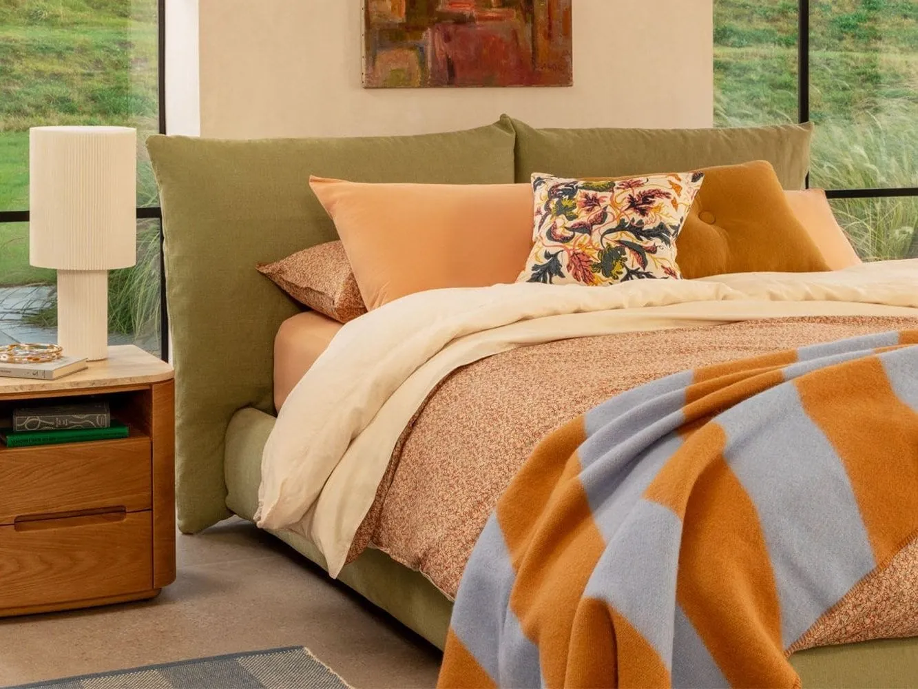 Moss-green fabric upholstered storage bed with pillow-style headboard
