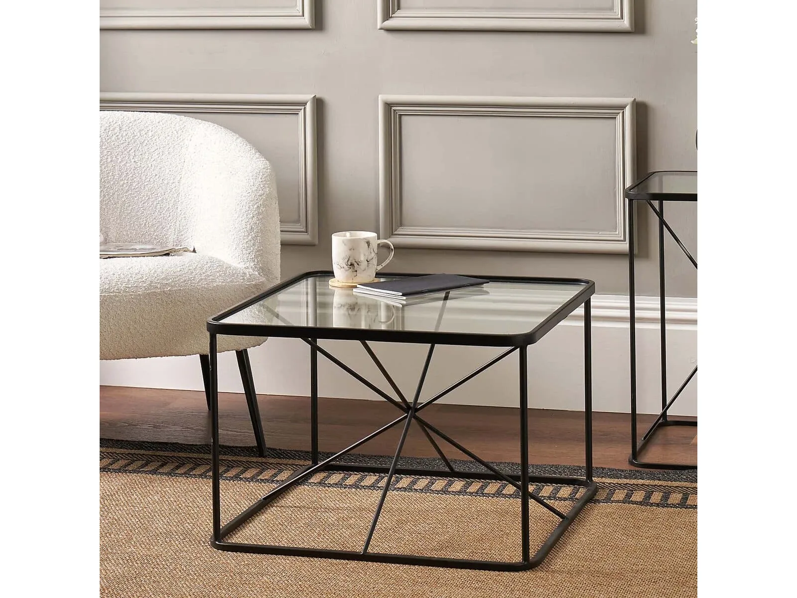 Black square coffee table with metal frame and glass top