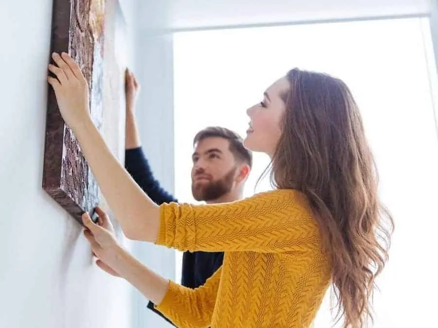 Couple hanging a picture on the wall