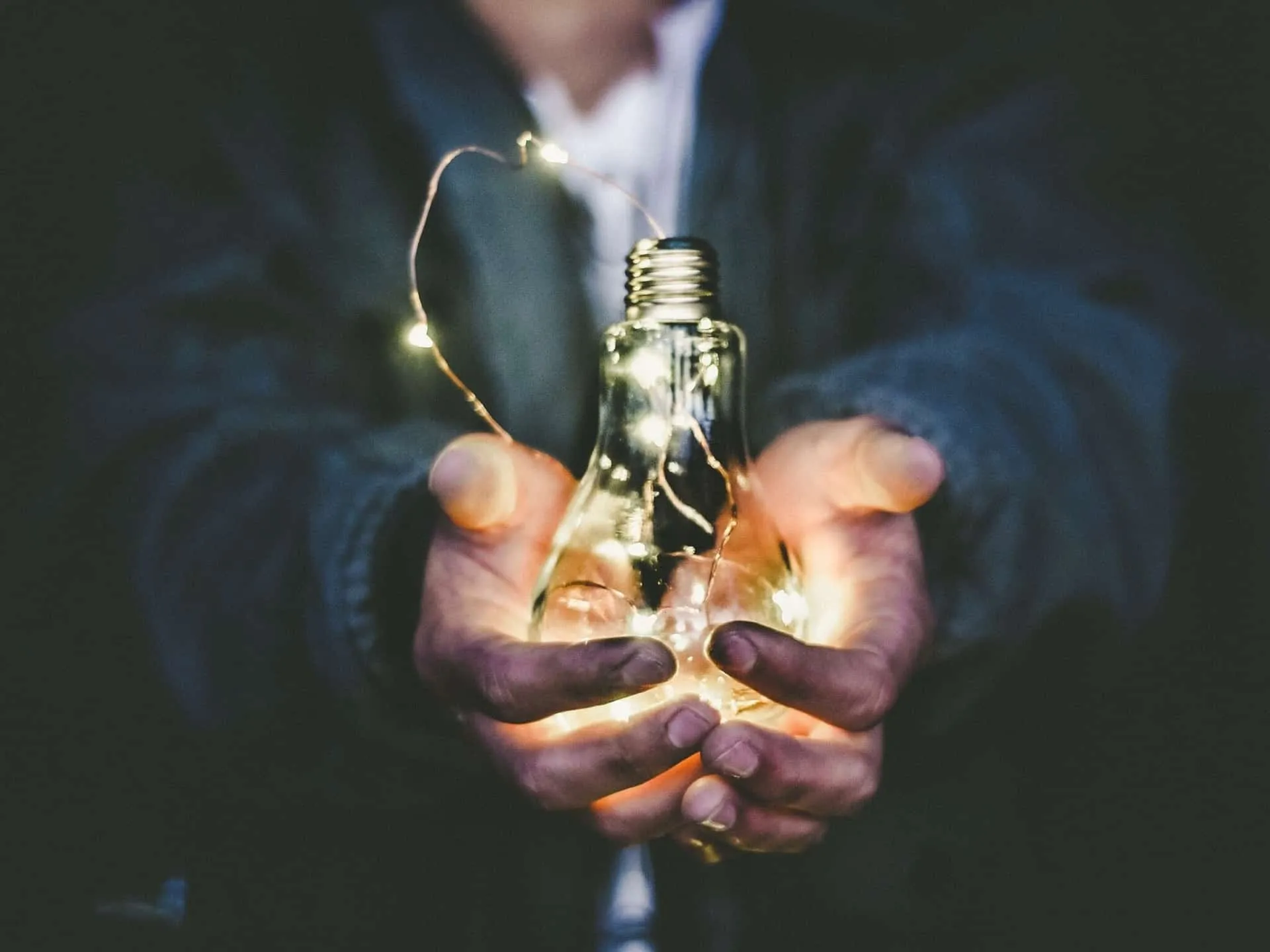 Holding a lit light bulb