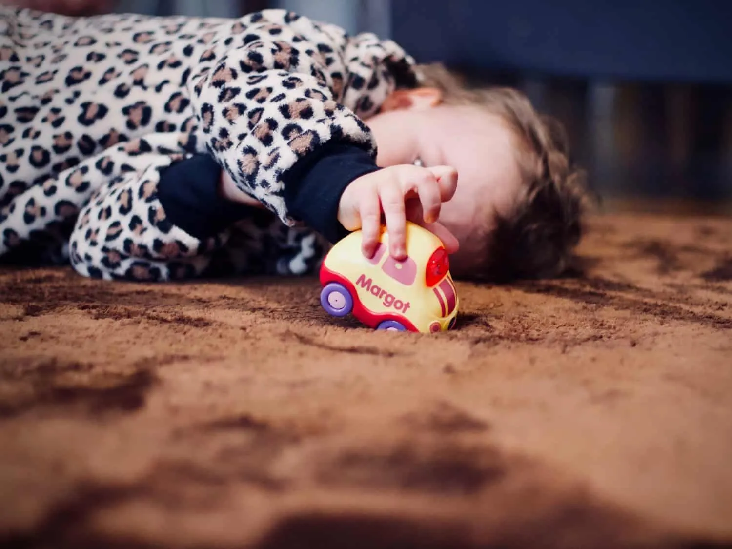 Child playing on a brown carpet